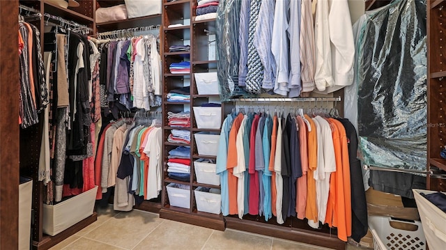 walk in closet with light tile patterned floors