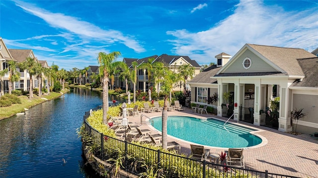 view of swimming pool featuring a water view and a patio area