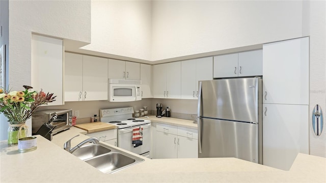 kitchen with sink, white cabinets, and white appliances