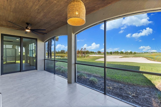 unfurnished sunroom featuring ceiling fan and wooden ceiling