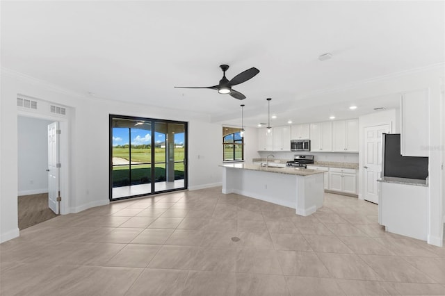 kitchen featuring appliances with stainless steel finishes, a kitchen island with sink, sink, decorative light fixtures, and white cabinets