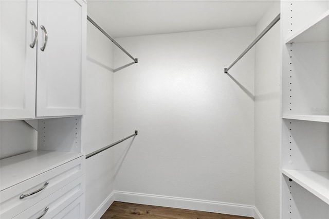 walk in closet with dark wood-type flooring