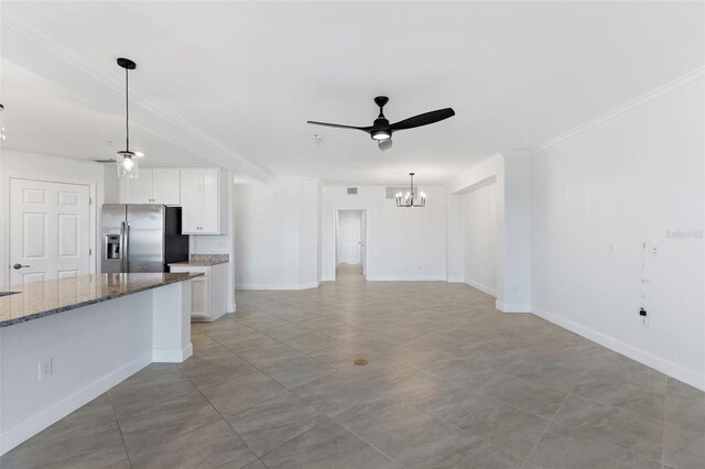 unfurnished living room with ceiling fan with notable chandelier and crown molding