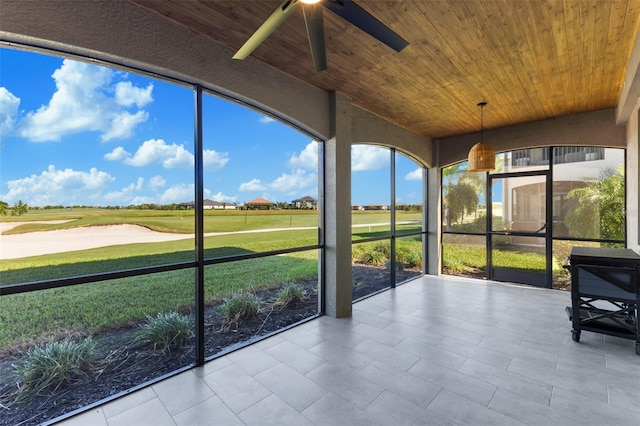 unfurnished sunroom with ceiling fan and wooden ceiling