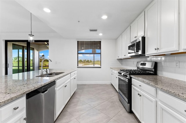 kitchen with sink, decorative backsplash, appliances with stainless steel finishes, light stone counters, and white cabinetry