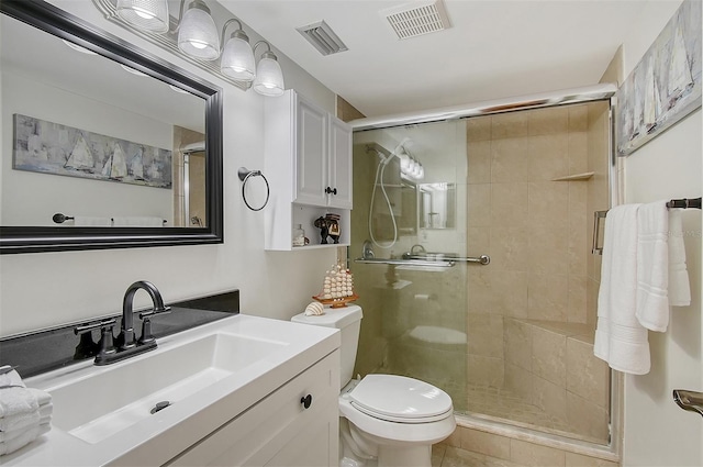 bathroom featuring vanity, toilet, and a shower with shower door