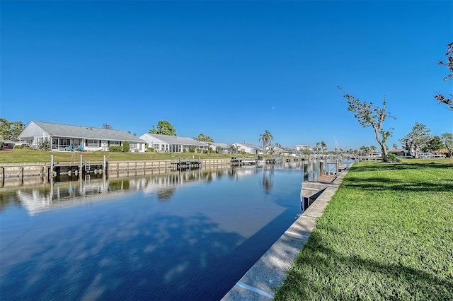 dock area with a water view and a yard