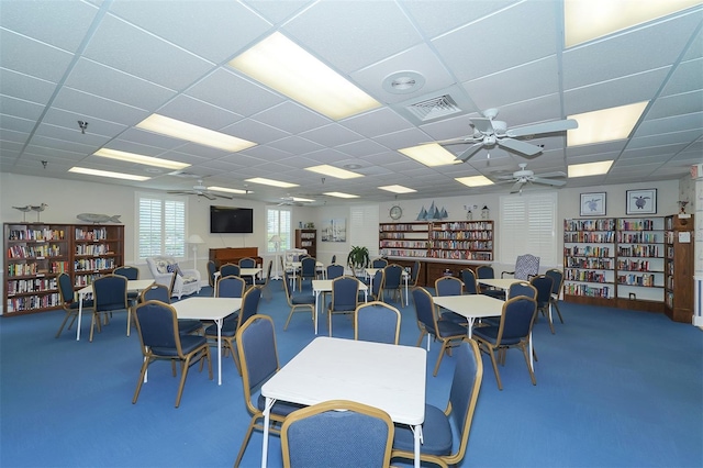 dining area featuring carpet, a drop ceiling, and ceiling fan