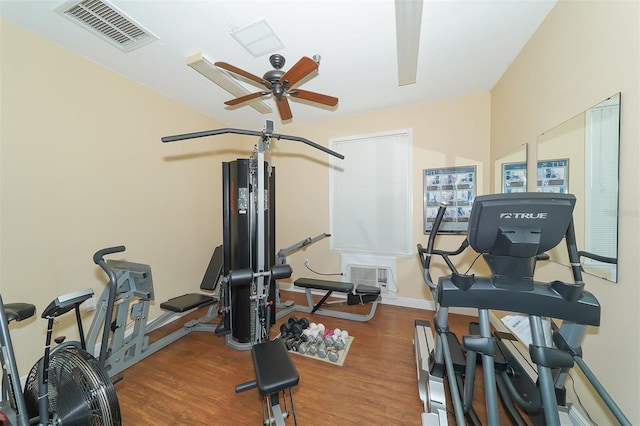 exercise area with ceiling fan and dark wood-type flooring