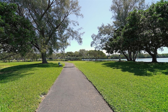 view of home's community with a water view and a lawn