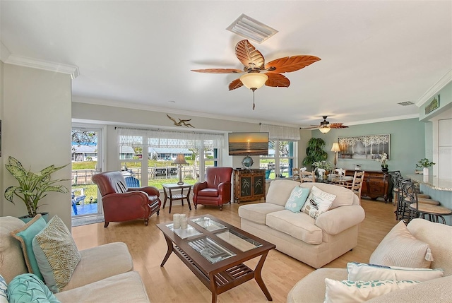 living room with crown molding and light hardwood / wood-style floors