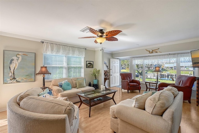 living room featuring light hardwood / wood-style floors, plenty of natural light, crown molding, and ceiling fan