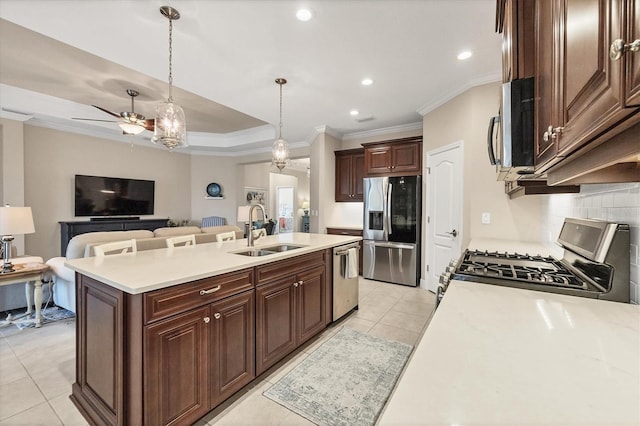 kitchen featuring appliances with stainless steel finishes, tasteful backsplash, a kitchen island with sink, sink, and pendant lighting