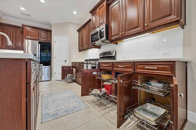 kitchen featuring backsplash, light tile patterned floors, stainless steel appliances, and ornamental molding