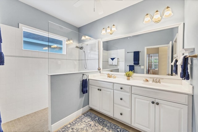 bathroom featuring tile patterned floors, ceiling fan, vanity, and tiled shower