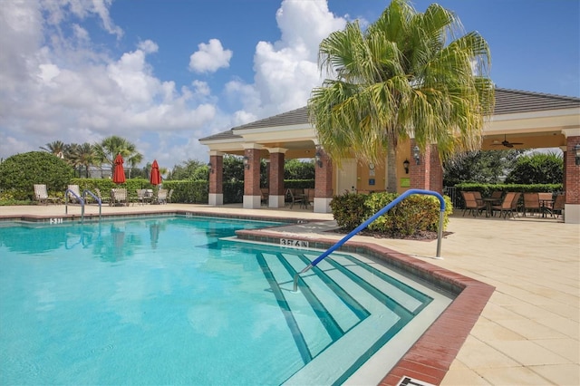 view of swimming pool with ceiling fan and a patio area