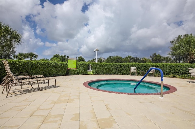 view of pool with a patio and a hot tub