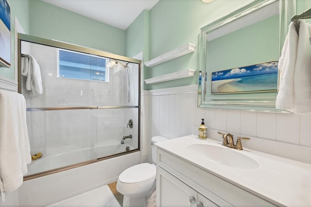 full bathroom featuring vanity, enclosed tub / shower combo, and toilet