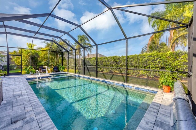 view of swimming pool with glass enclosure and a patio