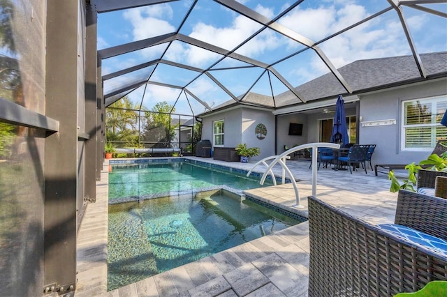 view of swimming pool featuring glass enclosure, an in ground hot tub, and a patio