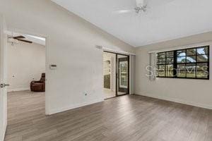 unfurnished room featuring wood-type flooring, vaulted ceiling, and ceiling fan