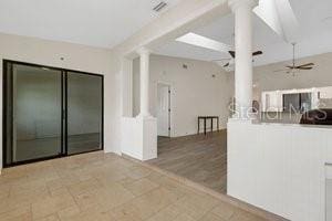 interior space with ceiling fan and decorative columns