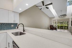 kitchen with tasteful backsplash, stainless steel dishwasher, ceiling fan, sink, and white cabinetry