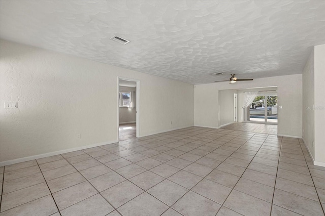 tiled empty room featuring a textured ceiling and ceiling fan