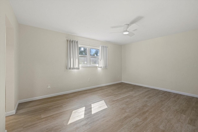 empty room with ceiling fan and light wood-type flooring