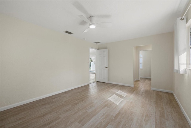 empty room with ceiling fan and light hardwood / wood-style floors