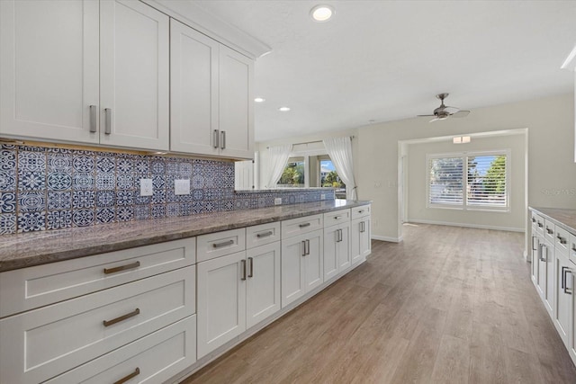 kitchen with decorative backsplash, white cabinetry, ceiling fan, and a healthy amount of sunlight