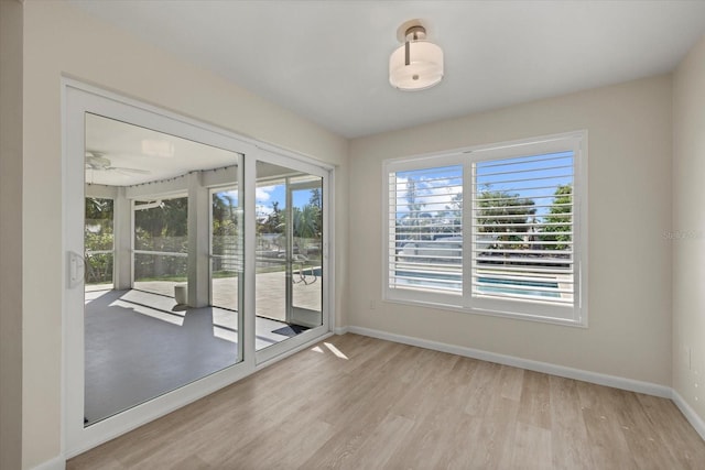 unfurnished room featuring light wood-type flooring, ceiling fan, and a healthy amount of sunlight