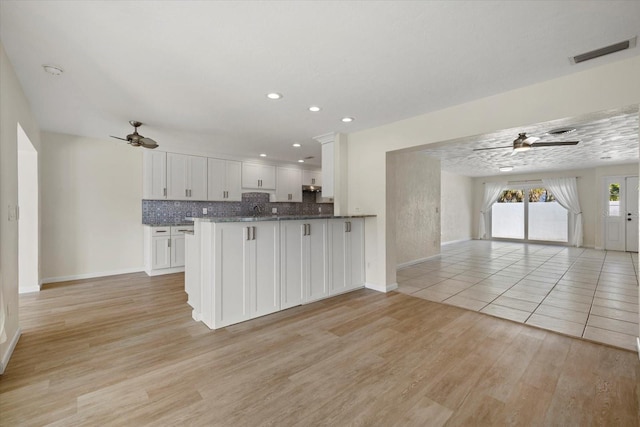 kitchen featuring ceiling fan, light hardwood / wood-style floors, white cabinetry, and kitchen peninsula