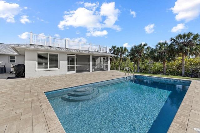 view of pool featuring central air condition unit, a sunroom, and a patio