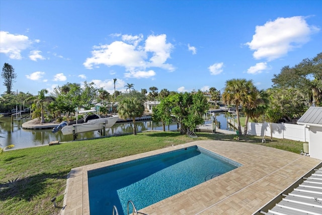 view of swimming pool featuring a patio, a water view, and a lawn