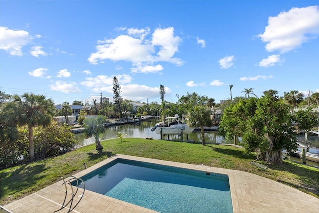 view of swimming pool featuring a yard, a water view, and a patio