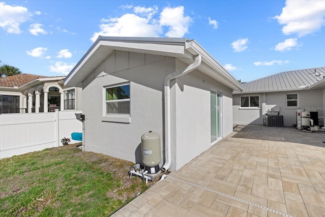 view of side of property with a patio and a lawn