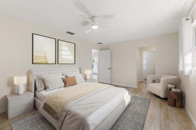 bedroom featuring light wood-style floors, visible vents, ceiling fan, and baseboards