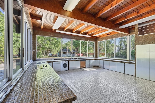 unfurnished sunroom with beam ceiling, washer / dryer, and wooden ceiling