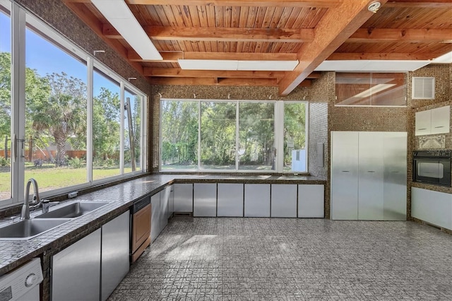 kitchen with black oven, beamed ceiling, sink, white dishwasher, and wooden ceiling