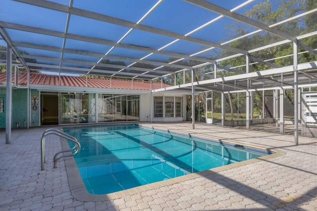 view of pool with a patio area and glass enclosure