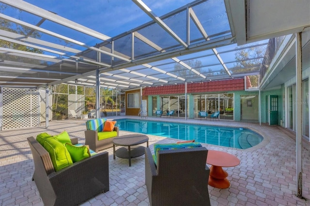 view of swimming pool with an outdoor living space, a lanai, and a patio area