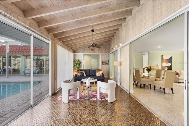 sunroom / solarium featuring lofted ceiling with beams, wood ceiling, and ceiling fan