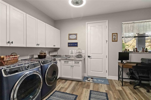 washroom with separate washer and dryer, cabinets, and light hardwood / wood-style floors