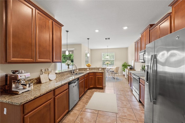 kitchen featuring sink, kitchen peninsula, pendant lighting, light tile patterned flooring, and appliances with stainless steel finishes