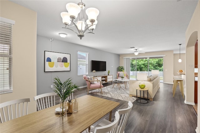 dining space featuring ceiling fan with notable chandelier and dark hardwood / wood-style floors