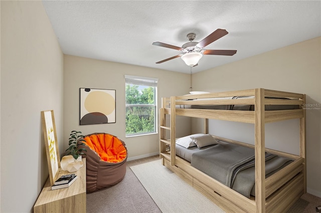 bedroom featuring ceiling fan, carpet, and a textured ceiling