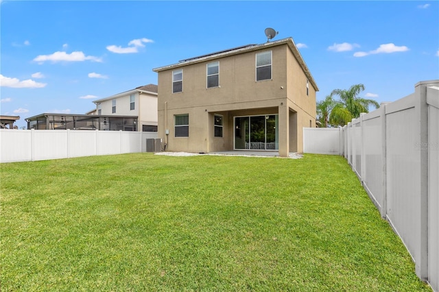 back of property with cooling unit and a lawn