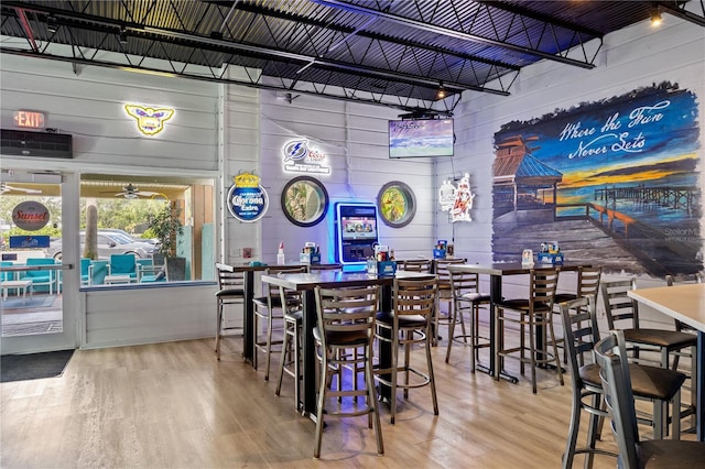 bar with hardwood / wood-style floors and wooden walls