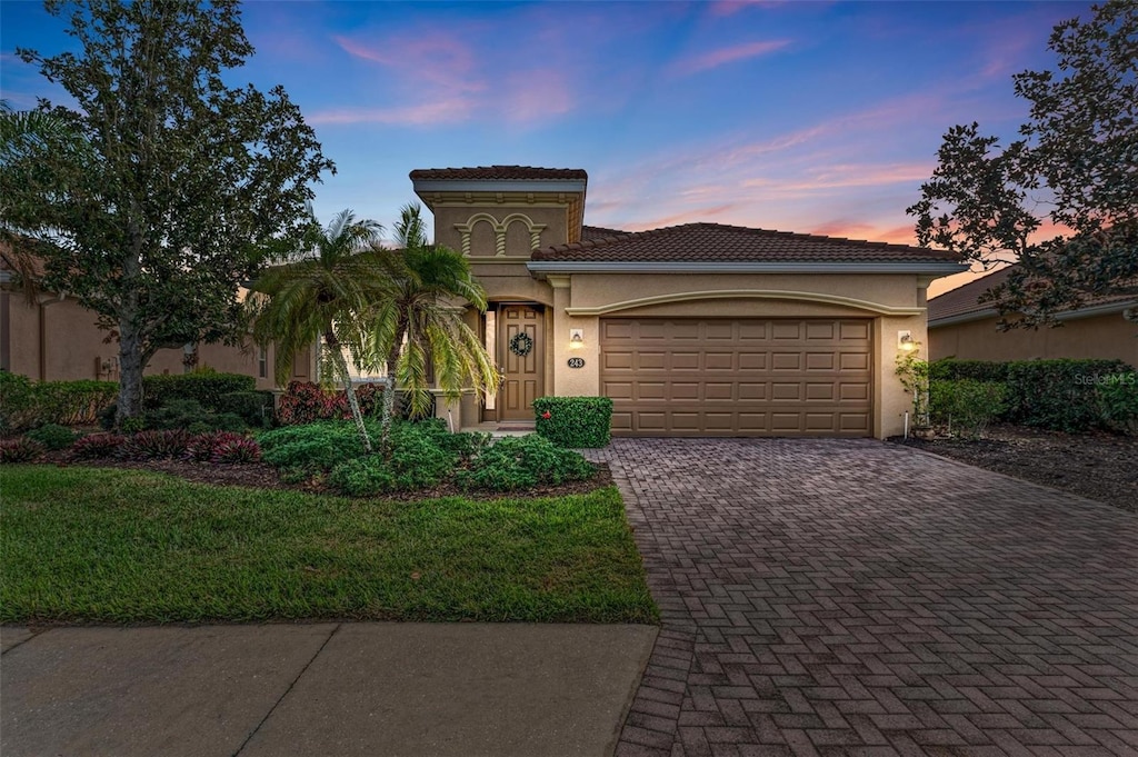 mediterranean / spanish-style home featuring a lawn and a garage